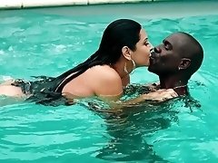 Dashing brunette works her magic by the pool in sexy interracial