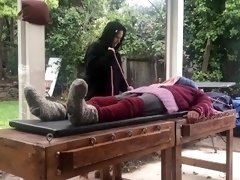 Sweater sissy tied to bondage table outside