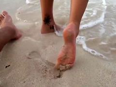 Enticing babe in a sexy bikini gives a footjob on the beach
